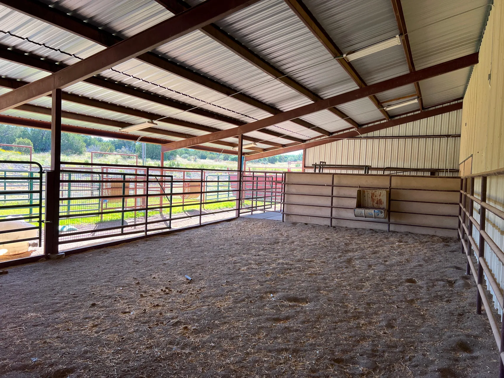 Open-air covered pen and equipment storage off the barn