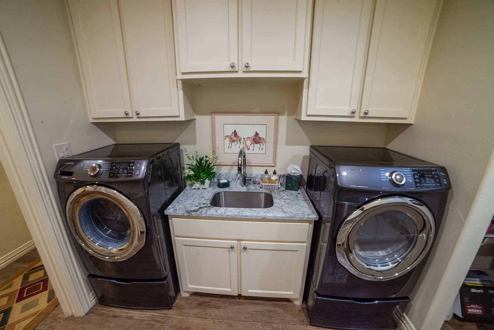 Laundry sink with marble counters between washer and dryer