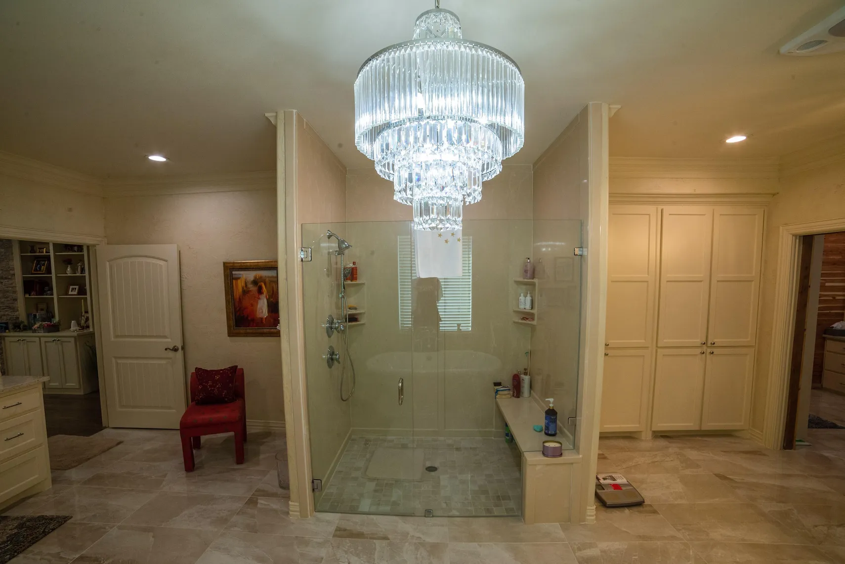 Walk-in shower beneath a crystal chandelier